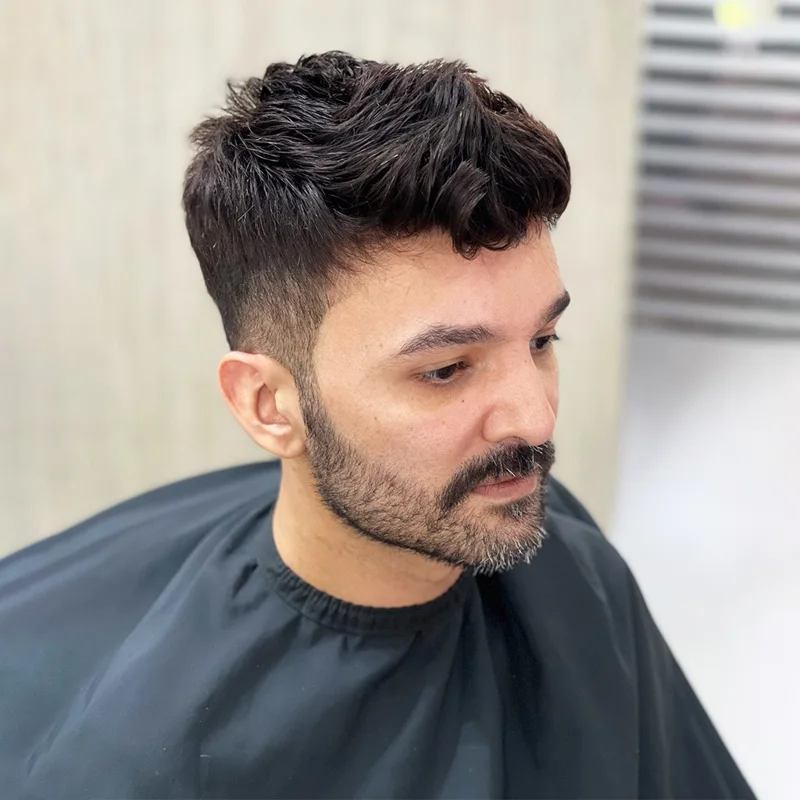 Client in a barber cape after cutting and styling