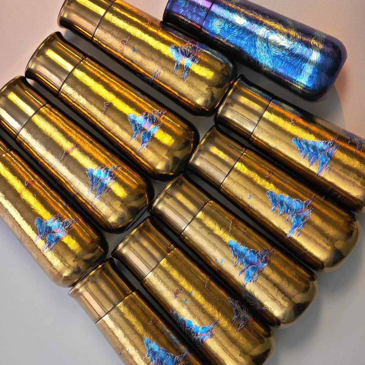 Gold hammered-texture bottle painted with small blue mountains – view 4