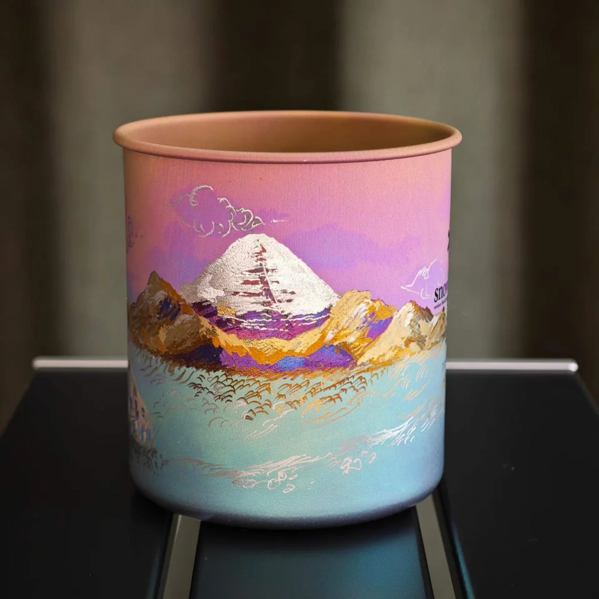 Camp mug painted with a golden snow peak under a pink dusk sky