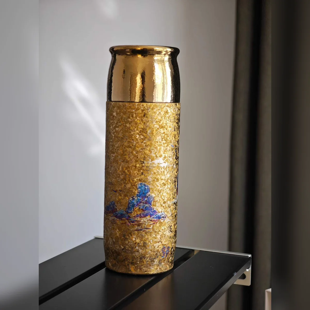 Gold hammered-texture bottle painted with small blue mountains – view 3