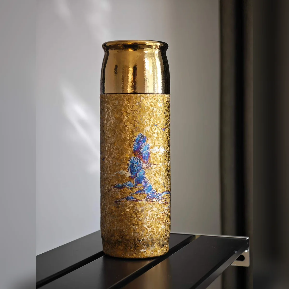 Gold hammered-texture bottle painted with small blue mountains – view 2