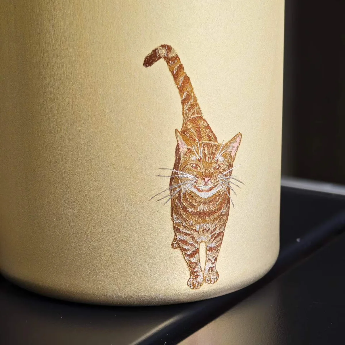 Champagne-colored mug painted with a walking ginger cat