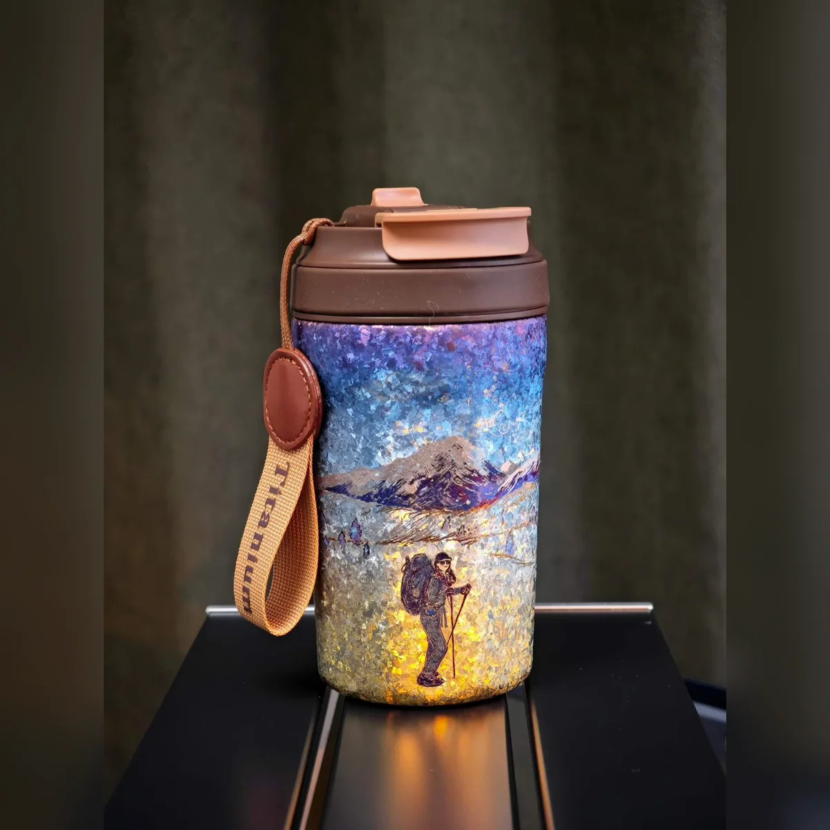 Travel tumbler painted with a hiker walking toward snowy mountains