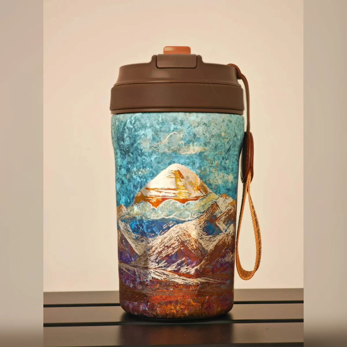 Travel tumbler painted with a golden snow peak