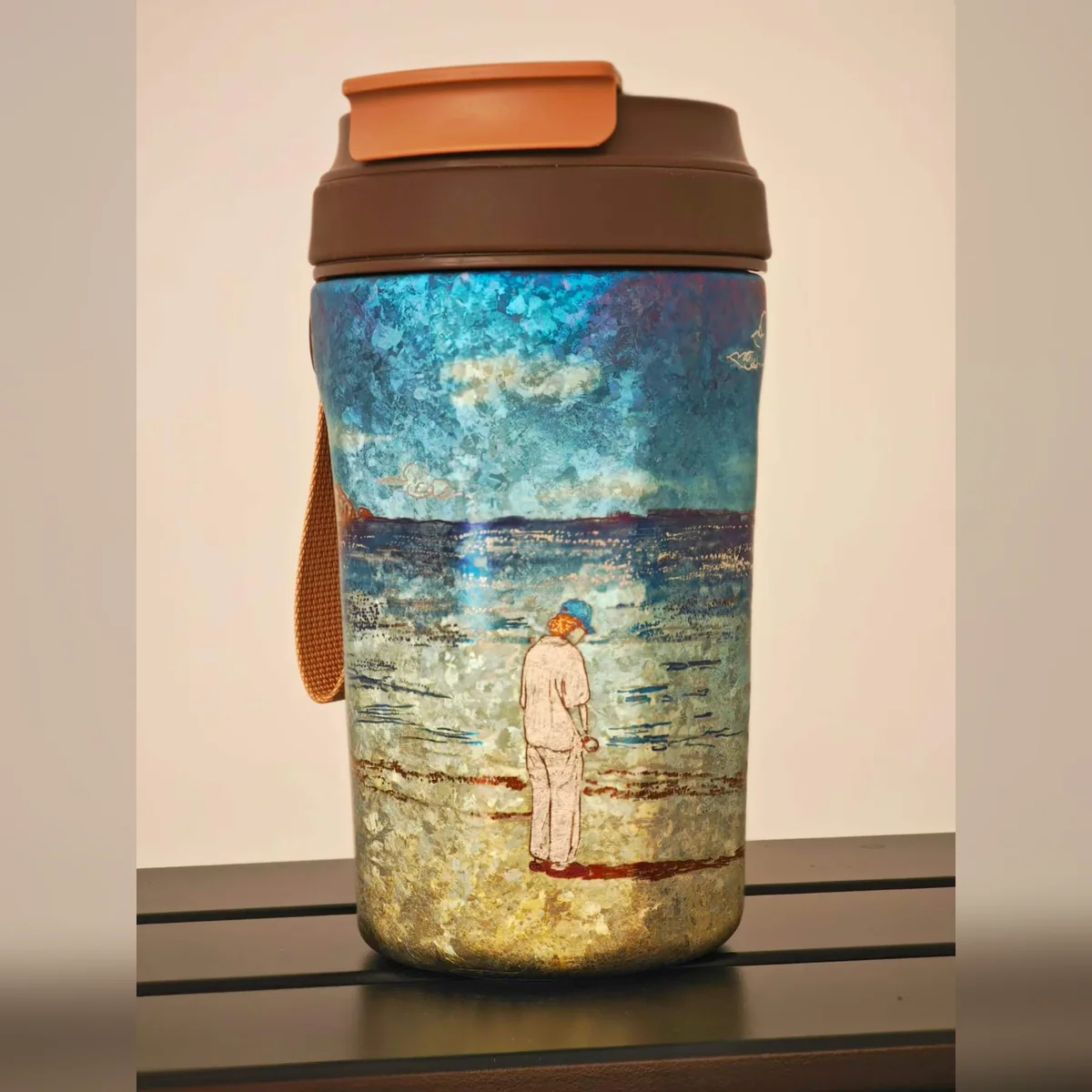 Travel tumbler painted with a figure standing by the sea